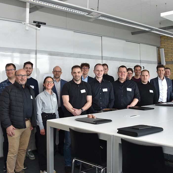 Gruppe von etwa 15 Personen in einem Besprechungsraum