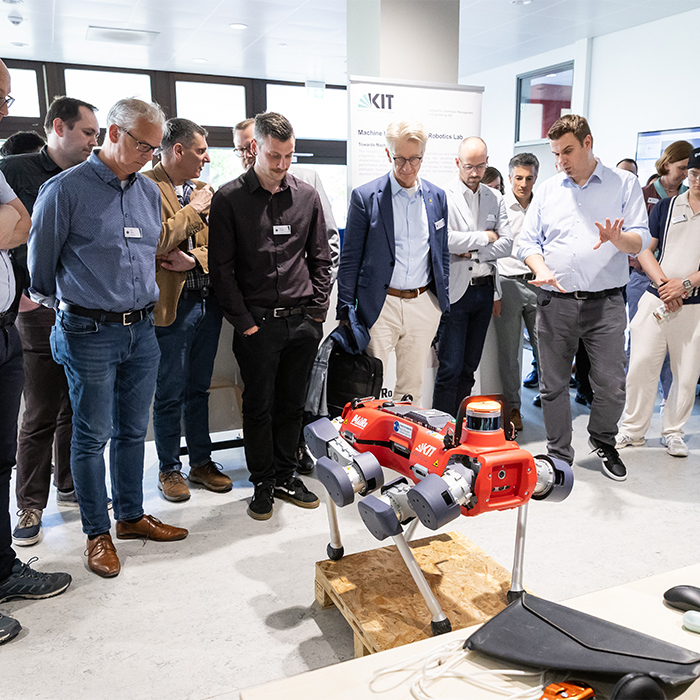 Gruppe von Personen beobachtet einen Roboter bei einer Demonstration